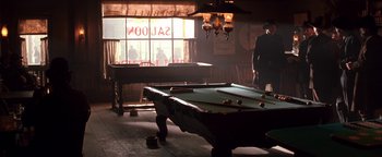 Movie still from “Wyatt Earp” (1994), directed by Lawrence Kasdan – A man standing in front of a billiards table; Wide shot, Low angle