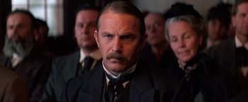 Movie still from “Wyatt Earp” (1994), directed by Lawrence Kasdan – A person wearing a suit and tie; Close Up shot, Low angle