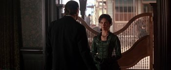 Movie still from “Wyatt Earp” (1994), directed by Lawrence Kasdan – A man and a woman standing next to each other in front of a railing; Medium shot, Over the shoulder angle