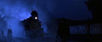 Movie still from “Wyatt Earp” (1994), directed by Lawrence Kasdan – A man walking on the train tracks at night; Wide shot, Low angle