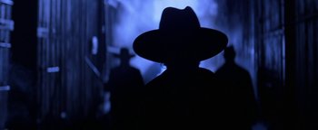 Movie still from “Wyatt Earp” (1994), directed by Lawrence Kasdan – A man wearing a hat is standing in the dark; Close Up shot, Low angle