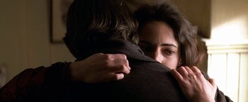 Movie still from “Wyatt Earp” (1994), directed by Lawrence Kasdan – A woman hugging another woman in a room; Close Up shot, Over the shoulder angle