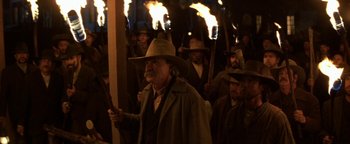 Movie still from “Wyatt Earp” (1994), directed by Lawrence Kasdan – A group of men in cowboy hats holding torches; Medium shot, Low angle