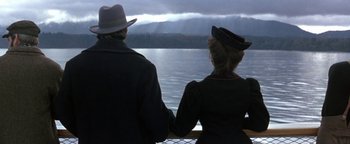 Movie still from “Wyatt Earp” (1994), directed by Lawrence Kasdan – A man and a woman sitting on a pier looking out at a body of water; Medium shot, Low angle