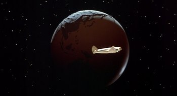Movie still from “Xanadu” (1980), directed by Robert Greenwald – An image of an airplane flying over the earth; Extreme Wide shot, Overhead angle