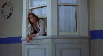Movie still from “Xanadu” (1980), directed by Robert Greenwald – A woman leaning up against a window sill; Medium shot, Low angle
