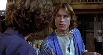 Movie still from “Xanadu” (1980), directed by Robert Greenwald – A man with long brown hair wearing a white shirt and a blue jacket; Close Up shot, Over the shoulder angle