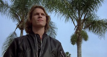 Movie still from “Xanadu” (1980), directed by Robert Greenwald – A young man standing in front of a palm tree; Close Up shot, Low angle