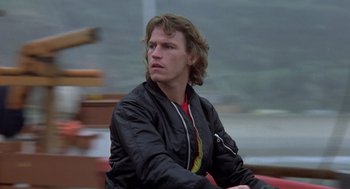 Movie still from “Xanadu” (1980), directed by Robert Greenwald – A man sitting on top of a boat in the water; Close Up shot, Low angle