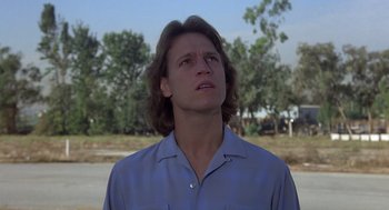 Movie still from “Xanadu” (1980), directed by Robert Greenwald – A man with long brown hair looking upward; Close Up shot, Low angle