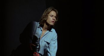 Movie still from “Xanadu” (1980), directed by Robert Greenwald – A young man holding an object in his hand; Close Up shot, Low angle