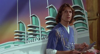 Movie still from “Xanadu” (1980), directed by Robert Greenwald – A man in a blue shirt is holding a paintbrush; Medium shot, Low angle