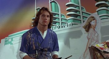 Movie still from “Xanadu” (1980), directed by Robert Greenwald – A man with long hair is painting a building; Medium shot, Low angle