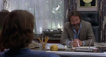 Movie still from “Xanadu” (1980), directed by Robert Greenwald – A man sitting at a table with a woman; Medium shot, Over the shoulder angle