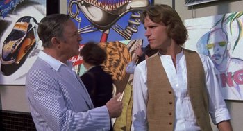Movie still from “Xanadu” (1980), directed by Robert Greenwald – A man and a woman standing next to each other in front of a painting; Medium shot, Over the shoulder angle