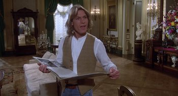 Movie still from “Xanadu” (1980), directed by Robert Greenwald – A man holding a newspaper while standing in front of a table; Medium shot, Over the shoulder angle