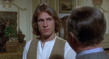 Movie still from “Xanadu” (1980), directed by Robert Greenwald – A man in a vest is talking to another man in front of him; Close Up shot, Over the shoulder angle