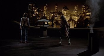 Movie still from “Xanadu” (1980), directed by Robert Greenwald – A couple of people that are standing in the dark; Wide shot, High angle