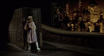 Movie still from “Xanadu” (1980), directed by Robert Greenwald – A young girl standing in front of a door; Wide shot, High angle