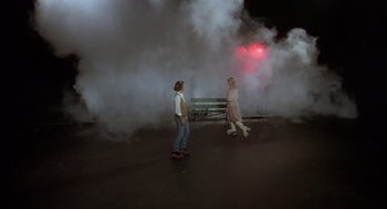 Movie still from “Xanadu” (1980), directed by Robert Greenwald – Two people on skatebaords in front of a bench; Wide shot, Low angle