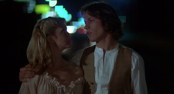 Movie still from “Xanadu” (1980), directed by Robert Greenwald – A man and a woman standing next to each other in front of lights; Close Up shot, Low angle