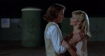 Movie still from “Xanadu” (1980), directed by Robert Greenwald – A man and a woman standing next to each other; Medium shot, Low angle