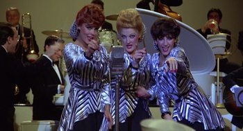 Movie still from “Xanadu” (1980), directed by Robert Greenwald – A group of three women in silver and black outfits are singing; Medium shot, High angle