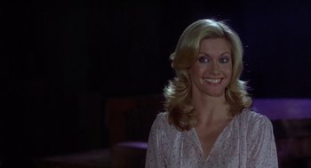 Movie still from “Xanadu” (1980), directed by Robert Greenwald – A woman with long blonde hair smiling for the camera; Close Up shot, Over the shoulder angle