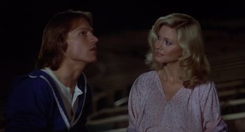 Movie still from “Xanadu” (1980), directed by Robert Greenwald – A man and a woman standing next to each other; Medium shot, Low angle