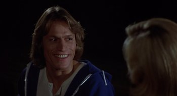 Movie still from “Xanadu” (1980), directed by Robert Greenwald – A person with a dog in a dark room; Close Up shot, Over the shoulder angle