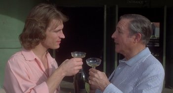 Movie still from “Xanadu” (1980), directed by Robert Greenwald – A man and a woman holding wine glasses; Close Up shot, Over the shoulder angle