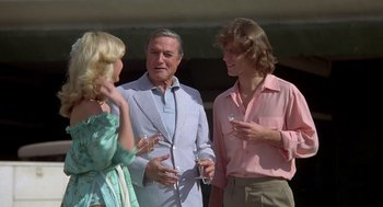 Movie still from “Xanadu” (1980), directed by Robert Greenwald – A group of people standing next to each other holding wine glasses; Medium shot, Over the shoulder angle