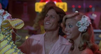 Movie still from “Xanadu” (1980), directed by Robert Greenwald – A man and a woman are posing for a picture; Close Up shot, Low angle