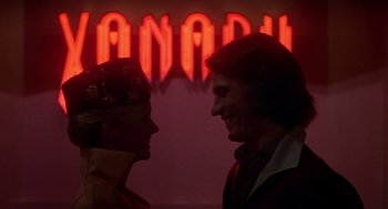 Movie still from “Xanadu” (1980), directed by Robert Greenwald – A man and a woman standing next to each other in front of a neon sign; Close Up shot, Over the shoulder angle