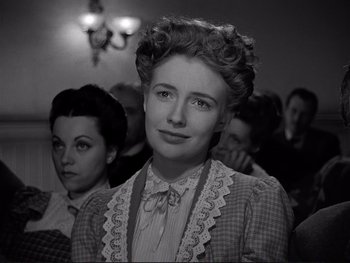 Movie still from “Yankee Doodle Dandy” (1942), directed by Michael Curtiz – An old photo of a woman in a crowd of people; Close Up shot, Low angle