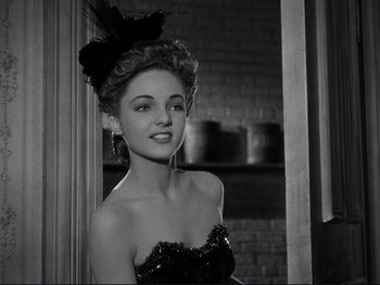 Movie still from “Yankee Doodle Dandy” (1942), directed by Michael Curtiz – A woman in a black dress with a black bow on her head; Close Up shot, Low angle