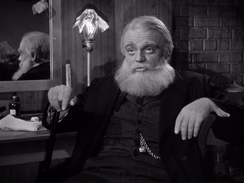 Movie still from “Yankee Doodle Dandy” (1942), directed by Michael Curtiz – An old man with a long beard sitting in front of a mirror; Medium shot, Low angle