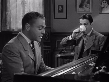 Movie still from “Yankee Doodle Dandy” (1942), directed by Michael Curtiz – Two men in suits are drinking coffee at a piano; Medium shot, Low angle
