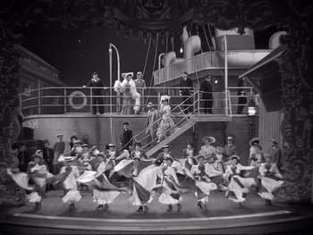 Movie still from “Yankee Doodle Dandy” (1942), directed by Michael Curtiz – A group of people on a stage performing a show; Extreme Wide shot, High angle