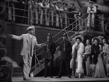 Movie still from “Yankee Doodle Dandy” (1942), directed by Michael Curtiz – A group of men and women standing on a stage; Wide shot, High angle