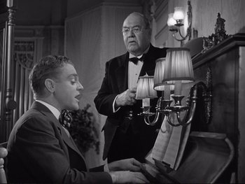 Movie still from “Yankee Doodle Dandy” (1942), directed by Michael Curtiz – Two men in suits are playing a piano; Medium shot, Low angle