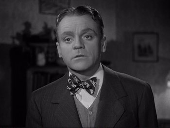 Movie still from “Yankee Doodle Dandy” (1942), directed by Michael Curtiz – An older man wearing a suit and a bow tie; Close Up shot, Low angle