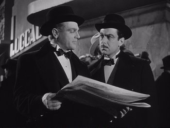 Movie still from “Yankee Doodle Dandy” (1942), directed by Michael Curtiz – A couple of men standing next to each other holding papers; Medium shot, Low angle