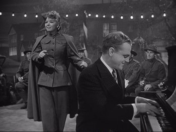 Movie still from “Yankee Doodle Dandy” (1942), directed by Michael Curtiz – A man and a woman in military garb; Medium shot, Low angle