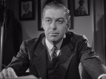 Movie still from “Yankee Doodle Dandy” (1942), directed by Michael Curtiz – An older man wearing a suit and tie in a room; Close Up shot, Low angle