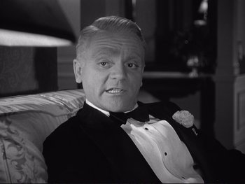Movie still from “Yankee Doodle Dandy” (1942), directed by Michael Curtiz – An older man in a tuxedo sitting in a chair; Close Up shot, Low angle