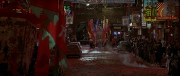 Movie still from “Year of the Dragon” (1985), directed by Michael Cimino – A street scene with people walking and cars driving down the road; Extreme Wide shot, High angle
