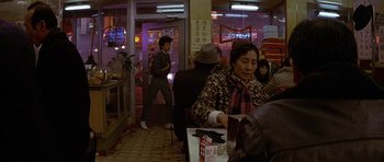 Movie still from “Year of the Dragon” (1985), directed by Michael Cimino – A group of people sitting at a table in a restaurant; Wide shot, High angle