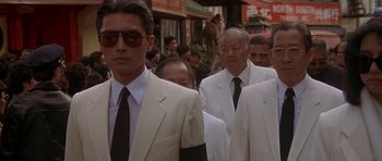 Movie still from “Year of the Dragon” (1985), directed by Michael Cimino – A group of men in white suits and black ties; Close Up shot, Low angle