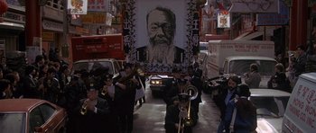 Movie still from “Year of the Dragon” (1985), directed by Michael Cimino – A group of men playing musical instruments in front of a mural; Wide shot, High angle